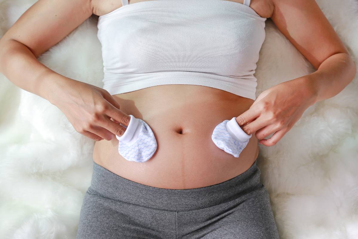 Schwangere Frau hält Babysocken