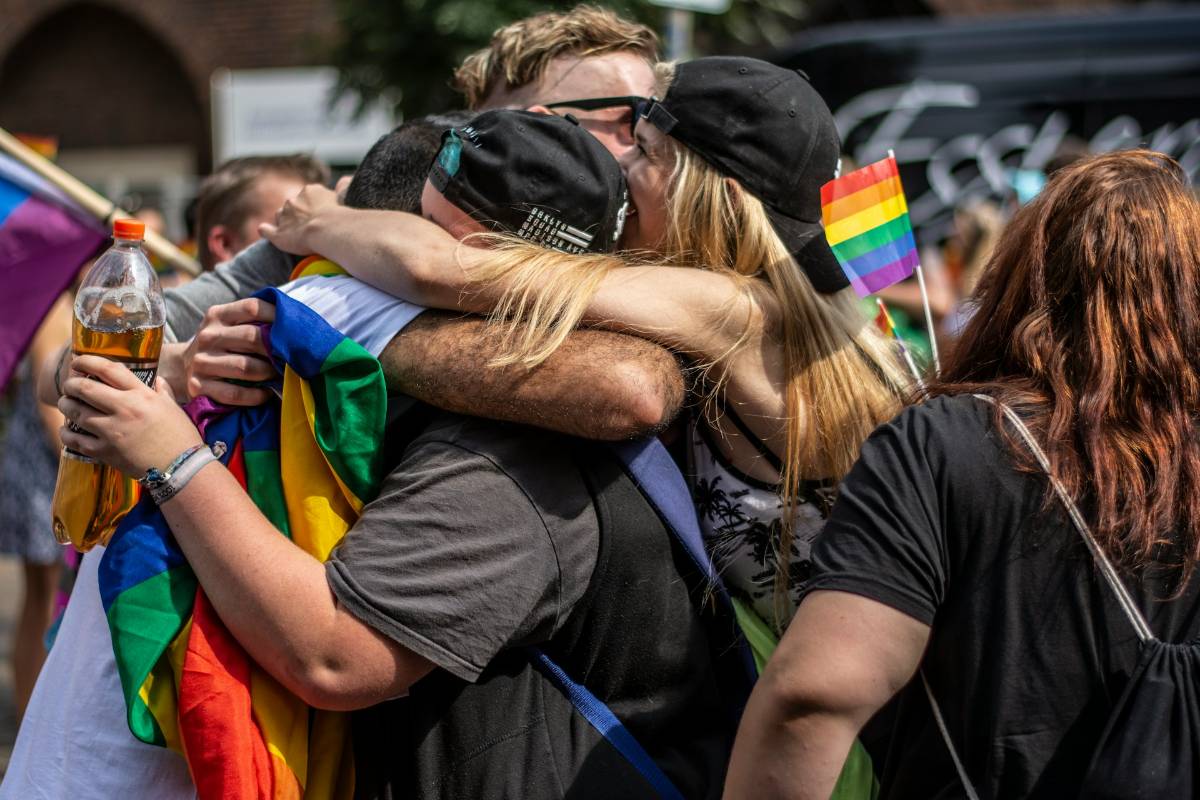 Fröhliche Menschen mit Regenbogenflagge Fröhliche Menschen mit Regenbogenflagge