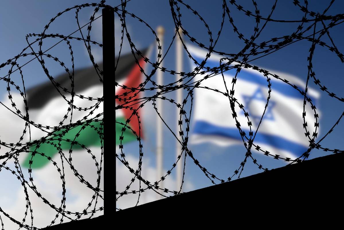 Flaggen von Israel und Palästina hinter Stacheldrahtzaun