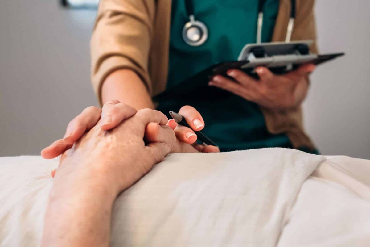 Eine Ärztin hält die Hand einer Patientin.
